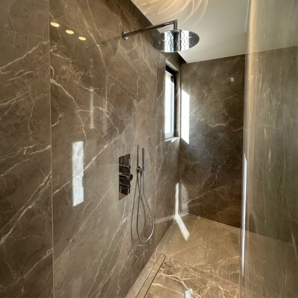 douche à l'italienne avec revêtement en marbre marron brillant à Cannes